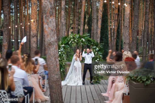 happy newlyweds at the outdoor wedding reception - wedding reception stock pictures, royalty-free photos & images