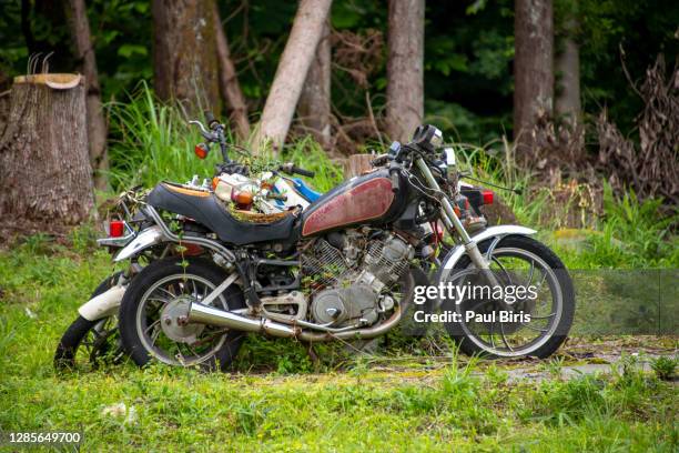 motorcycles that were sadly left to rot, japan - damaged fence stock pictures, royalty-free photos & images
