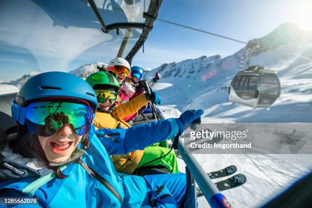 família curtindo esquiar no dia ensolarado de inverno - teleférico veículo terrestre comercial - fotografias e filmes do acervo
