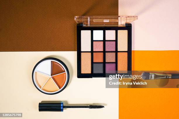 set of beauty products laid out on a colorful background. - gold eyeshadow imagens e fotografias de stock