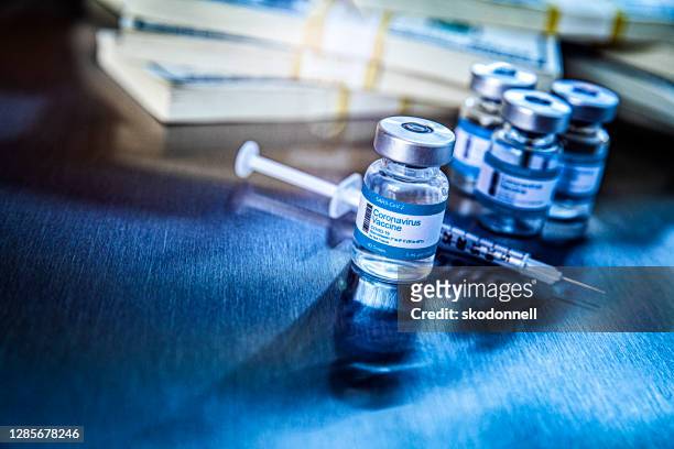coronavirus vaccine vials in hospital with money - covid 19 vaccine stock pictures, royalty-free photos & images