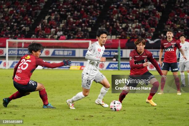 Ryota Oshima of Kawasaki Frontale controls the ball under pressure from Yasushi Endo and Rikuto Hirose of Kashima Antlers during the J.League Meiji...