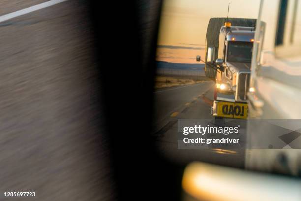 a closeup view of a long haul semi truck in the rearview mirror following too close behind - close to stock pictures, royalty-free photos & images