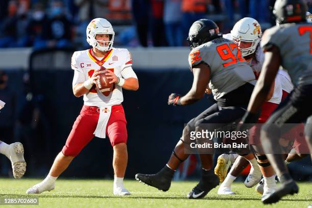 Quarterback Brock Purdy of the Iowa State Cylcones looks for a receiver against defensive tackle Cameron Murray of the Oklahoma State Cowboys in the...