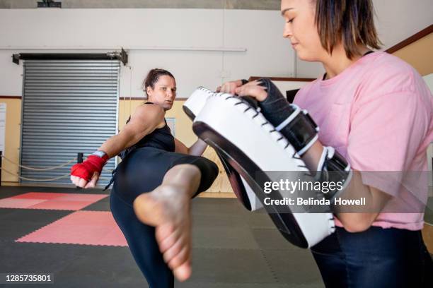 strong female martial arts athletes in their dojo training - australian defence stock-fotos und bilder