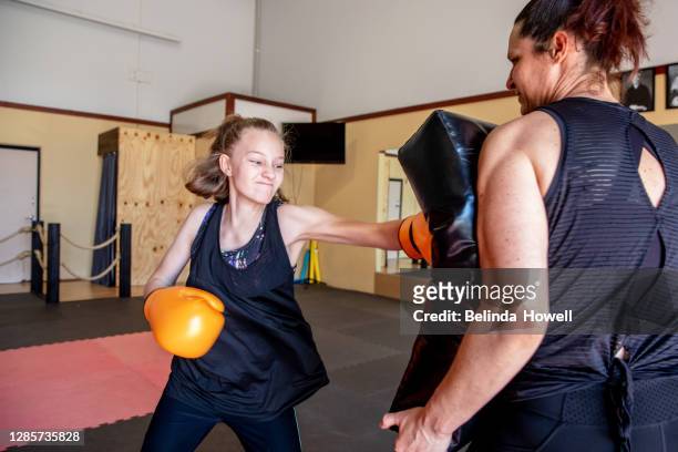 strong female martial arts athletes in their dojo training - blocking sports activity stock pictures, royalty-free photos & images