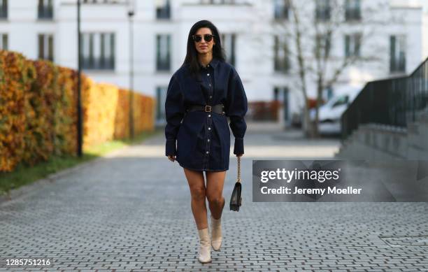 Semra Hunt wearing Dior bag and belt, beige Celine boots and Zara jeans dress on November 13, 2020 in Hamburg, Germany.