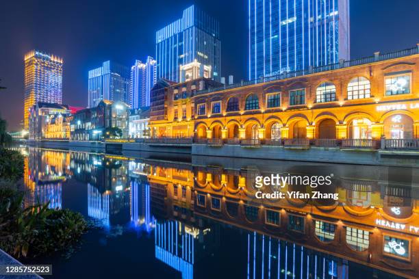 wuhan city center with its reflection on the water at night - wuhan photos et images de collection