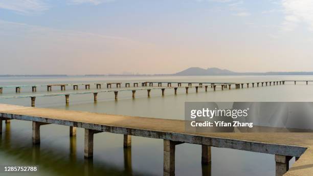 the trestle bridge in wuhan east lake at daytime - wuhan photos et images de collection