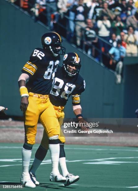 Wide receivers John Stallworth and Lynn Swann of the Pittsburgh Steelers walk back to the huddle after a play during a National Football League game...