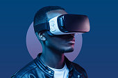 African american man standing at night with VR headset on. Virtual reality concept.