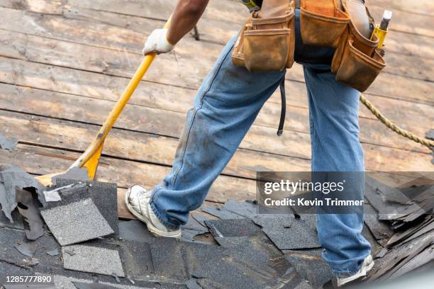 roofer removing old shingles from roof of house - bältros bildbanksfoton och bilder