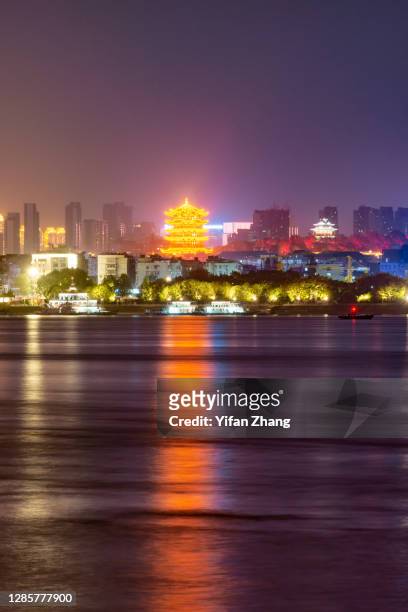 distant perspective of wuhan cityscape with its reflection on the water at night - wuhan photos et images de collection