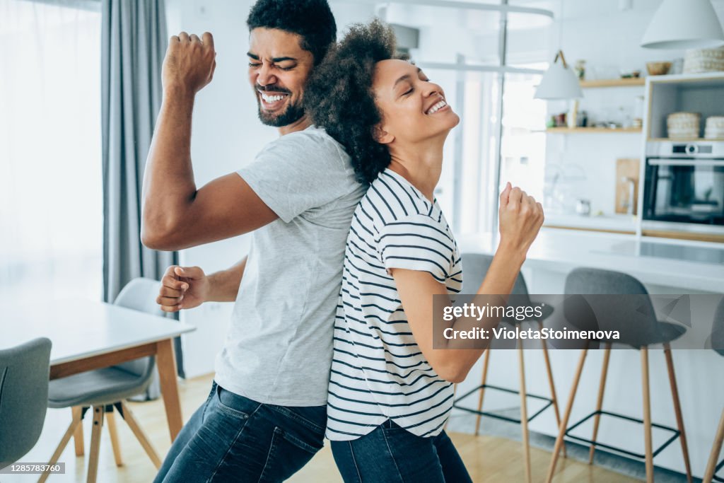 Couple dancing in living room.