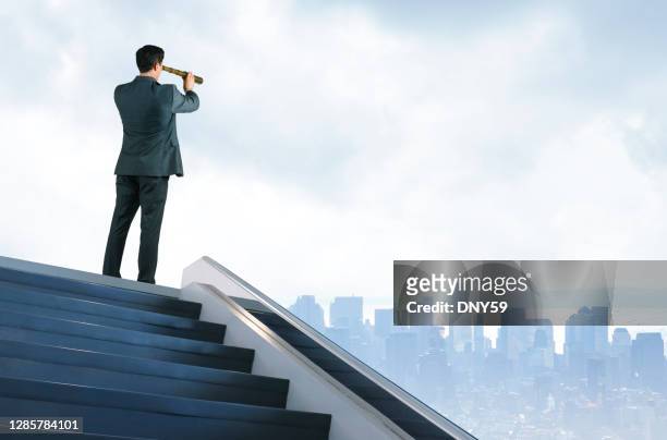 businessman at top of stairs looking toward large city in the distance - see through stock pictures, royalty-free photos & images