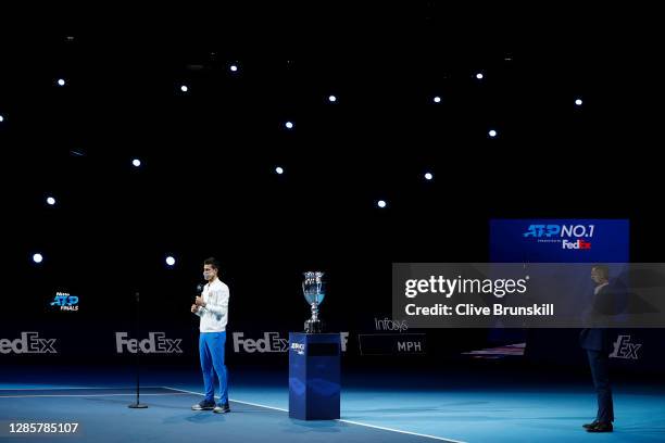 Novak Djokovic of Serbia wears a face mask / covering as he speaks to the arena before he collects his trophy after being announced as ATP Tour end...