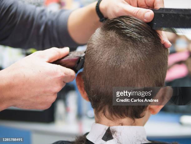 detail of the head of a young boy having a haircut - barbiere foto e immagini stock