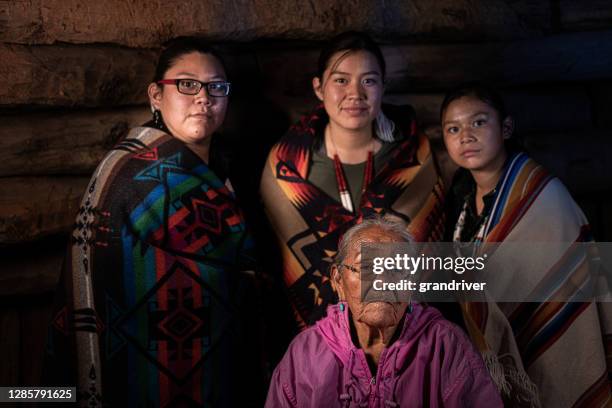a fine art portrait of a native american grandmother and her three granddaughters in their family hogan - american family fine art stock pictures, royalty-free photos & images