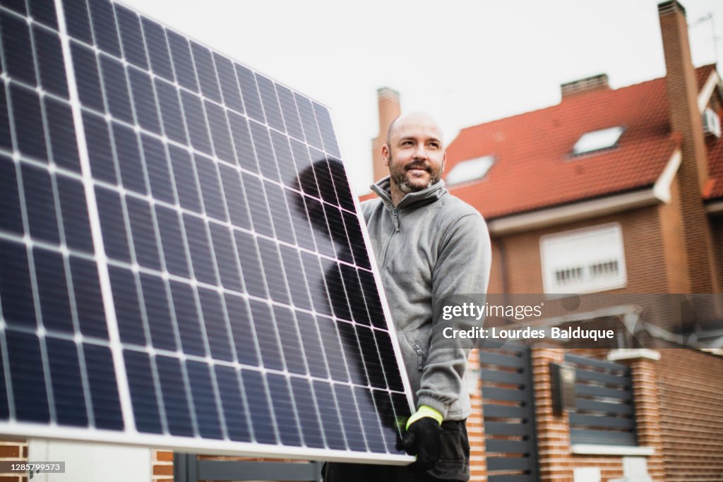 Construction worker installing solar panels