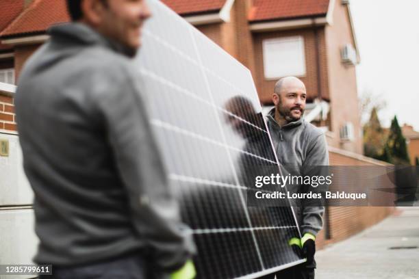 construction worker installing solar panels - green economy stockfoto's en -beelden