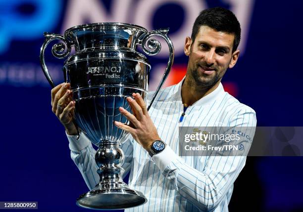 Novak Djokovic of Serbia is presented with the trophy for ending 2020 as the ATP number 1 player during Day 1 of the Nitto ATP World Tour Finals at...