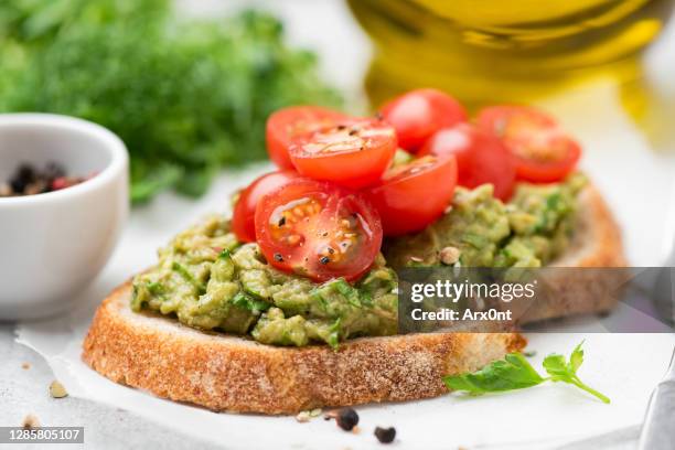 toast with avocado and tomatoes - avocato oil fotografías e imágenes de stock