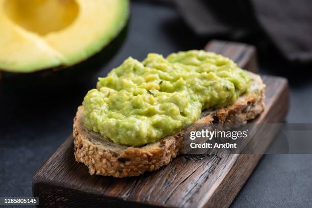 mashed avocado on toasted multigrain bread - trigo integral fotografías e imágenes de stock