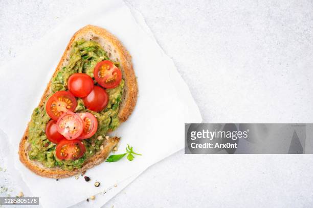 toast with mashed avocado and cherry tomatoes - crostini imagens e fotografias de stock