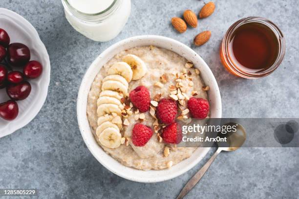 oatmeal porridge bowl with banana and raspberries - quinoa stockfoto's en -beelden