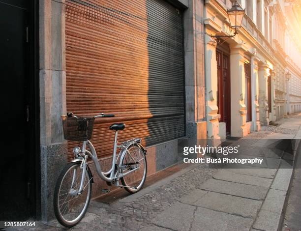 bike leaning on street wall with historic buildings in the district of mitte, berlin, germany - berlin mitte stock-fotos und bilder