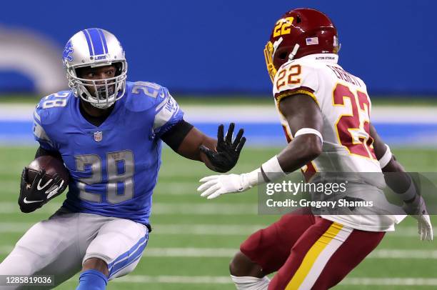 Adrian Peterson of the Detroit Lions attempts to run the ball against Deshazor Everett of the Washington Football Team during their game at Ford...