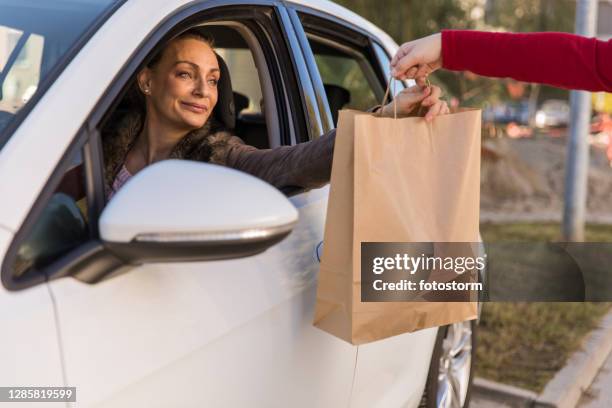 開車經過時拿起她的外賣午餐 - curbside pickup 個照片及圖片檔