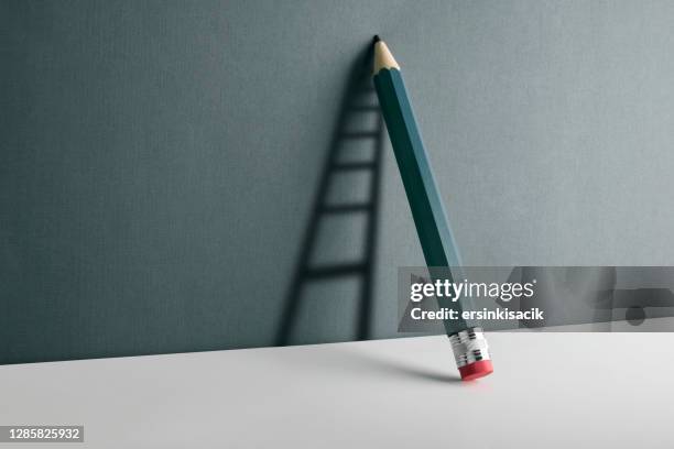 a pencil leaning against the wall. ladder shade reflect on the wall. - art direction stock pictures, royalty-free photos & images