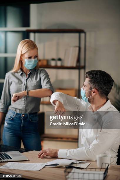 saludos de empresarios durante la foto de stock de pandemia covid-19 - elbow bump fotografías e imágenes de stock