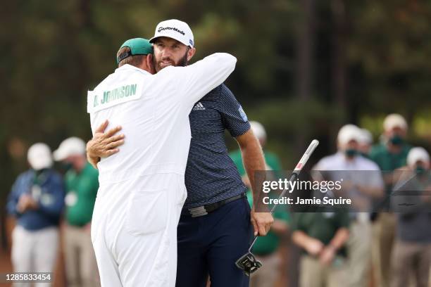 Dustin Johnson of the United States celebrates with caddie Austin Johnson on the 18th green after winning the Masters at Augusta National Golf Club...