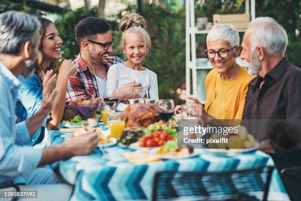 family gathered around the table on thanksgiving - al fresco dining stock pictures, royalty-free photos & images