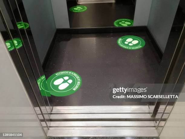 social distancing sticker signs in the lift of a corporate building in italy - social distancing elevator stock pictures, royalty-free photos & images
