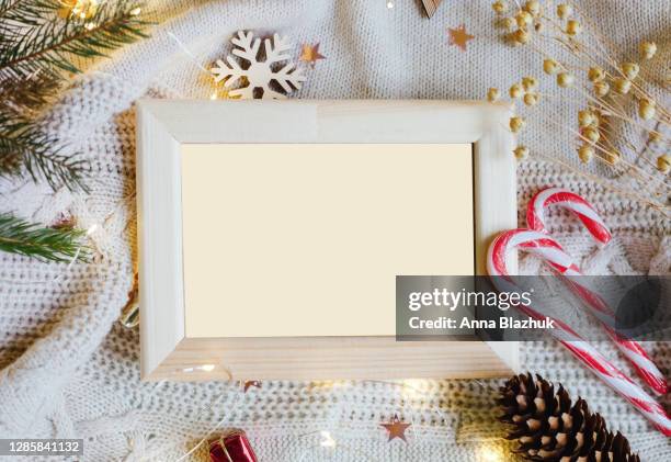 blank white wooden picture frame with copy space. christmas natural pine or fir tree branches background. christmas lights, pine cones and plant natural decorations. - birthday template picture stock pictures, royalty-free photos & images