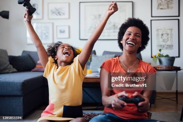 african american mother and daughter having fun at home - winning game stock pictures, royalty-free photos & images