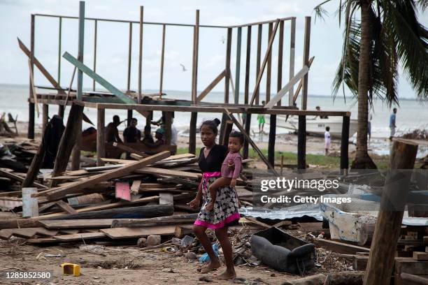 Woman walks holding her child through her destroyed house by hurricane ETA last month before the arrival of hurricane Iota on November 15, 2020 in...