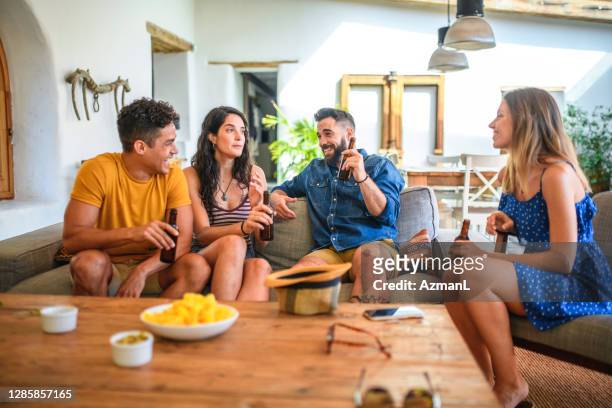 young friends at casual social gathering in home interior - coffee table front view stock pictures, royalty-free photos & images