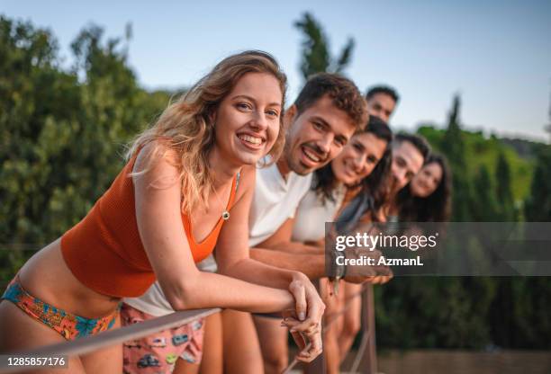 candid portrait of relaxed friends enjoying balcony view - leaning on elbows stock pictures, royalty-free photos & images
