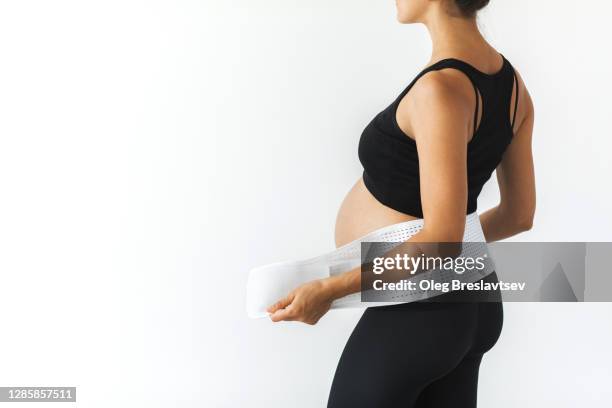pregnant woman in support bandage medical corset close up. rear view unrecognisable person. - orthopedic corset stock pictures, royalty-free photos & images