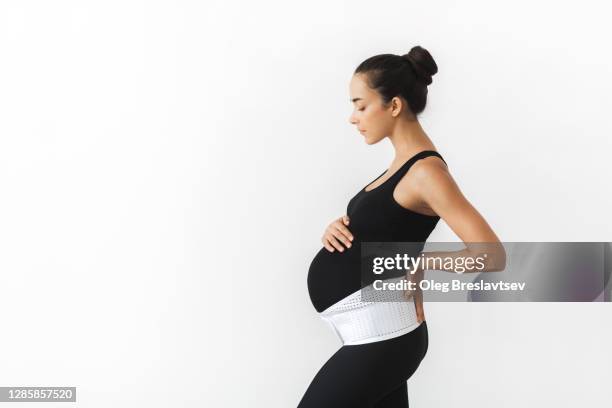 pregnant tired woman in support bandage medical corset. - orthopedic corset stock pictures, royalty-free photos & images