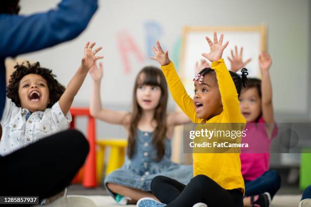 kleuters op het tapijt - kinderopvang stockfoto's en -beelden