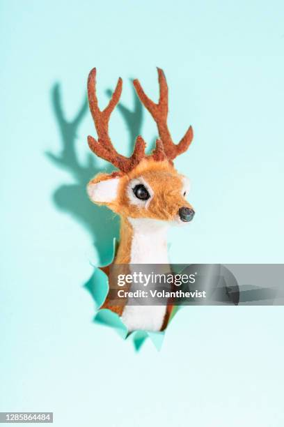 christmas reindeer toy on a light blue background - broken figurine stock pictures, royalty-free photos & images