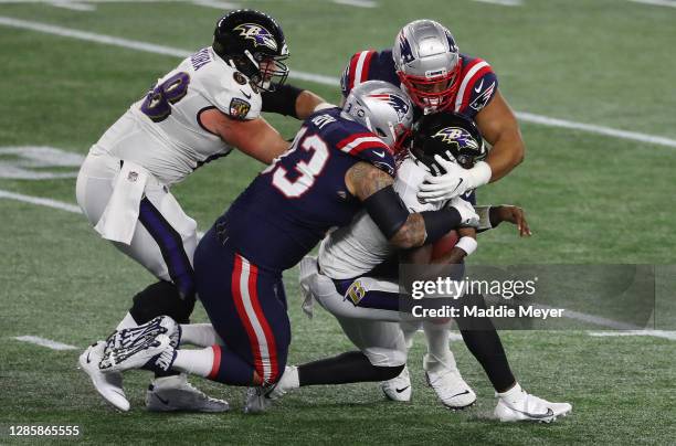 Lamar Jackson of the Baltimore Ravens is tackled by Lawrence Guy of the New England Patriots during the first quarter at Gillette Stadium on November...