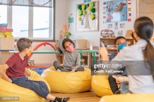 niños en bolsas de frijoles en el aula - bean bags fotografías e imágenes de stock