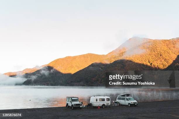 a group of seniors car camping by the lake. - motorhome winter stock-fotos und bilder