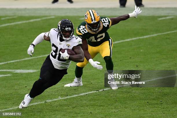 James Robinson of the Jacksonville Jaguars avoids a tackle by Oren Burks of the Green Bay Packers at Lambeau Field on November 15, 2020 in Green Bay,...